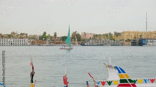Felucca boats are sailing on River Nile in Luxor, Egypt. Colorful wooden tourist boats on Nile. Nile boat tour