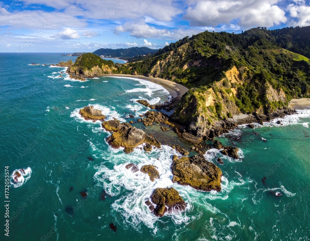 Fototapeta premium Coastal panorama with rocky outcrops, waves, and green hills