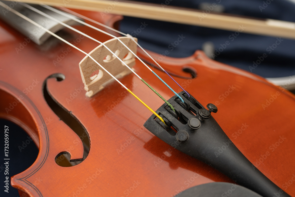 Fototapeta premium Close-up of a wooden violin showcasing the bridge, strings, and tuning pegs, highlighting craftsmanship and musical elements, perfect for music enthusiasts and instrument lovers