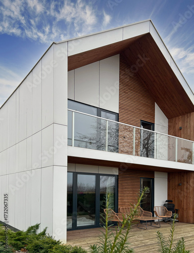 Luxurious, modern house facade, with natural materials and contemporary design. Landscape, sophisticated and eco-friendly architecture. Perfect for themes of contemporary living and real estate.