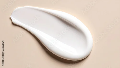 Naklejka Smooth, creamy white lotion smear on a light beige background