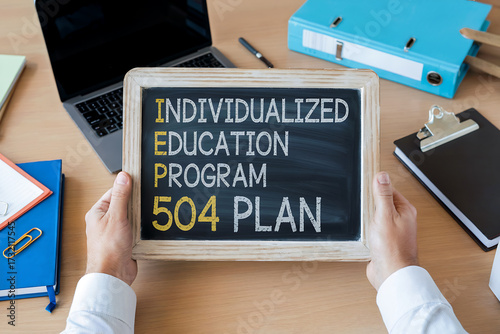 Hands hold blackboard with Individualized Education Program 504 Plan learning school