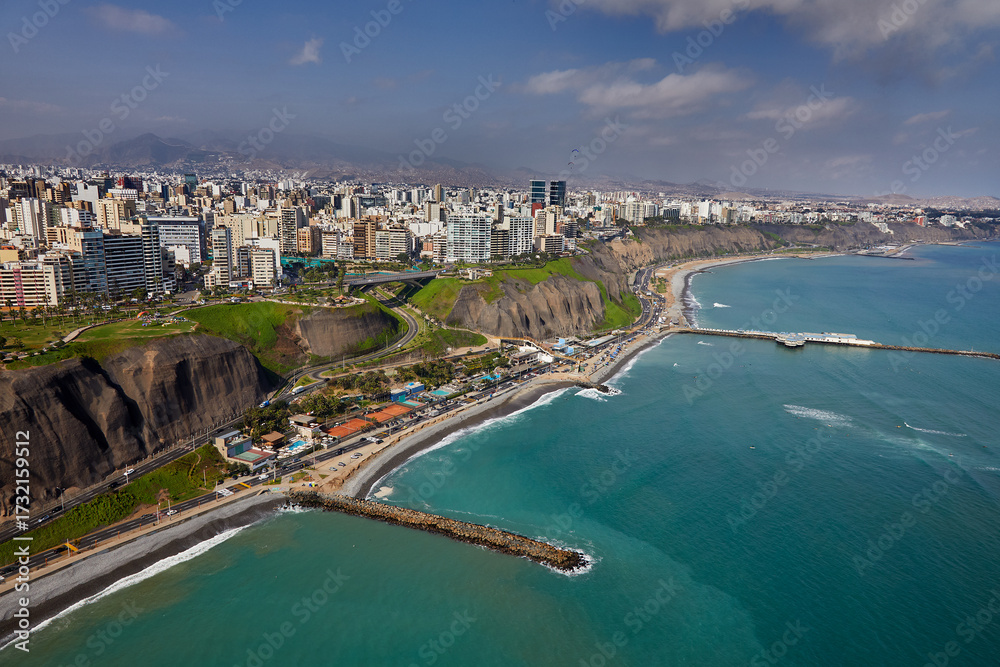 Fototapeta premium The thrill of paragliding over the stunning coastline of Miraflores is unmatched. With the ocean breeze at your back and the cityscape below.