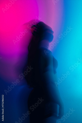 Dreamy moody cinematic portrait of a brunette woman with blue-green glow and long exposure