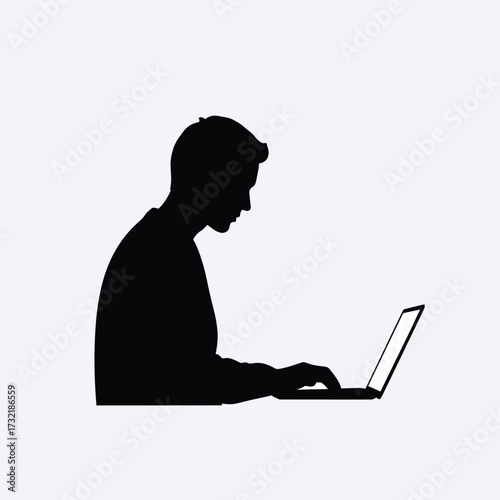 Silhouette of a person working diligently on a laptop computer in a profile view silhouette