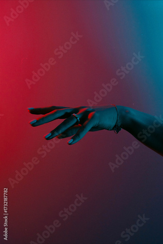 A person's hand reaching for something in the dark.