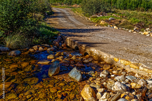 Stream known as Groot river (big river) flowing under simple concrete causeway in the foothills of the Swartberg Mountains in the Little Karoo, near Oudtshoorn, Western Cape