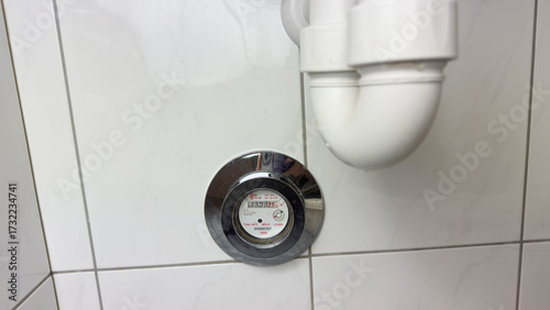 Wallpaper Mural Water meter installed on bathroom pipe under sink with chrome cover showing measurement dial for monitoring water consumption and utility usage in residential apartment or modern household plumbing sy Torontodigital.ca