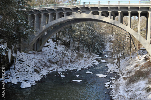 Youngstown Salem Road arched bridge over Mill Creek in winter with a dusting of snow and ice in Mill Creek Park, Youngstown, Ohio