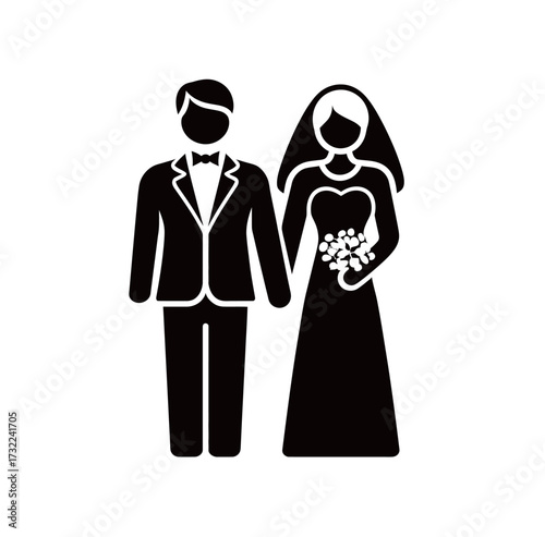 A groom in a tuxedo stands next to a bride in a long wedding dress, both holding hands in a joyful moment at their wedding ceremony.