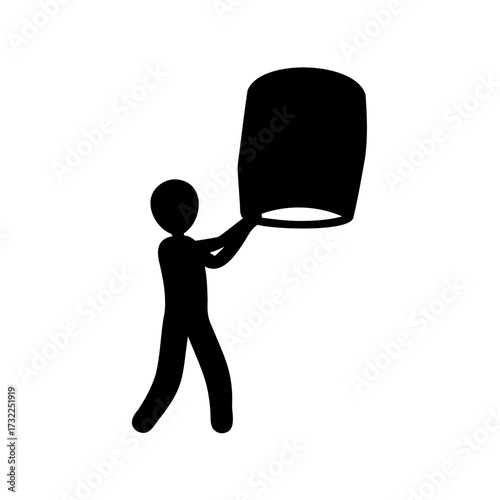 Silhouette of a person releasing a sky lantern at a festival