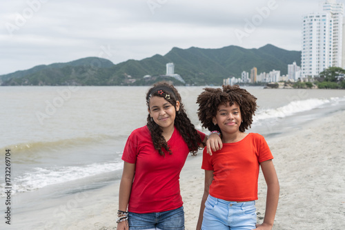 Smiling young girls enjoying friendship on the beach