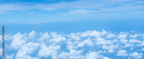 Beautiful landscape view trough window of airplane and cloudless sundown sky behind window of aircraft during flight. blue sky. Flying in the sky and the sea of clouds.