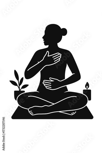 Woman doing breathwork seated on yoga mat, hand on chest and belly, silhouette