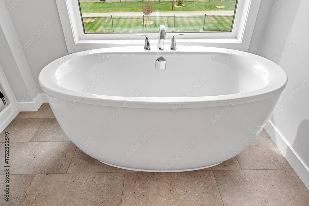 Fototapeta premium White bathtub with a faucet and a window above it