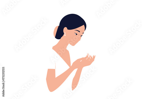 Woman with dark hair gazes at a ring held in her hands