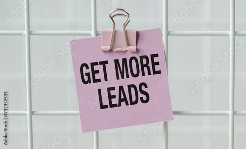 A pink note with a clip on it that says Get more leads