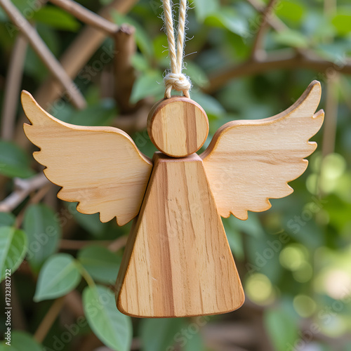 Wooden angel ornament hanging in greenery, festive decoration