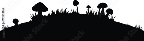 Dark silhouette of mushrooms and grass on a hill silhouette