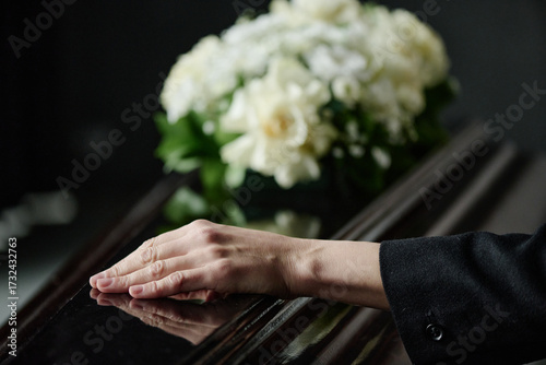 Obraz na plátne Caucasian middle aged woman resting hand on closed coffin during funeral ceremon