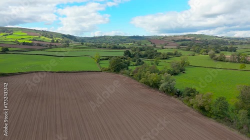 Aerial panning shot of Shropshire countryside in the UK near the village of Clun, an example of the beautiful UK countryside