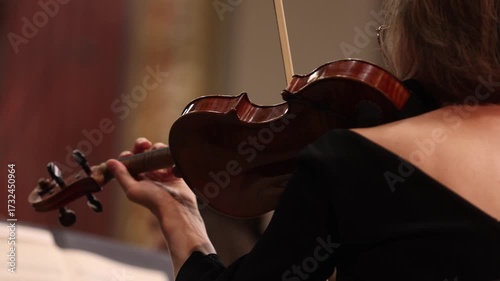 Unrecognizable violin player performing in orchestra ensemble 