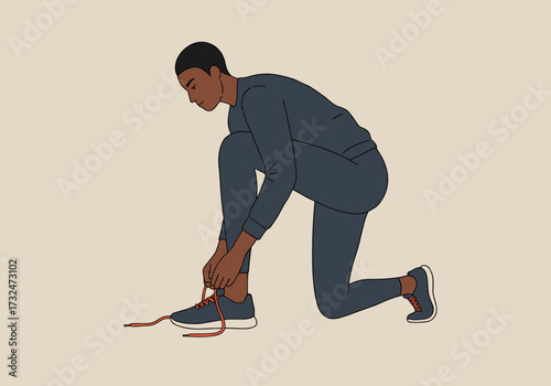 Lacing up sneakers a young man prepares for exercise in a minimalist indoor setting