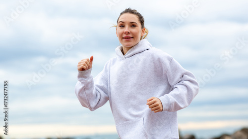 Happy young woman jogging outdoors