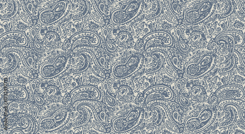 Dense paisley pattern in faded blue-gray on a light, textured background