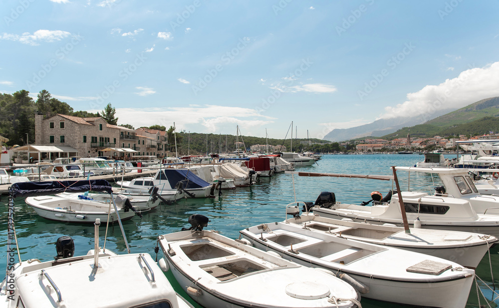 Fototapeta premium Motorboats moored along marina pier in quiet bay