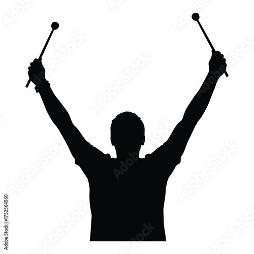Silhouette of a drummer raising drumsticks high in celebration or performance silhouette