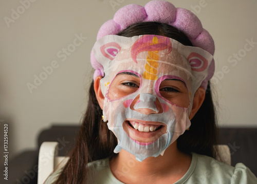 Female kid using beauty face mask for skincare - Treatment, social media trend and childhood concept