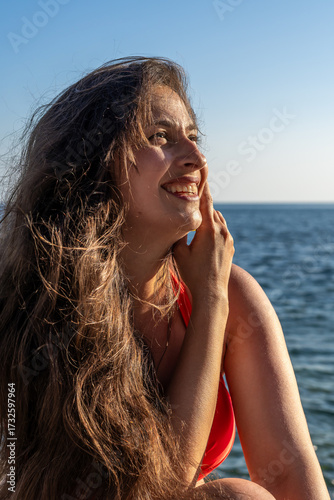 Woman smiling ocean, happy young woman with long flowing hair enjoying sun by the sea, summer vacation