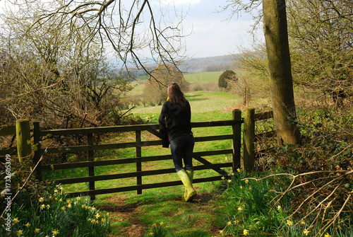 Woman in wellies looking at the countryside in the UK