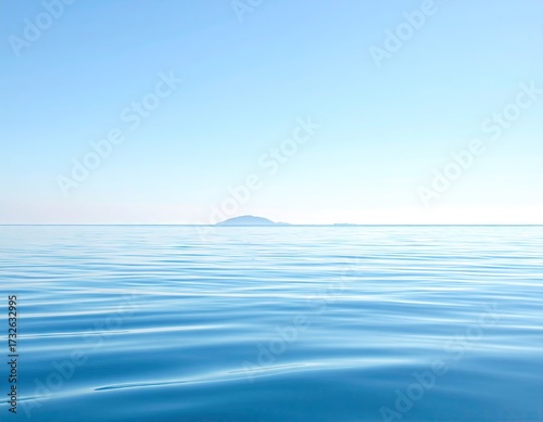 Calm Ocean with Distant Island Under a Clear Blue Sky