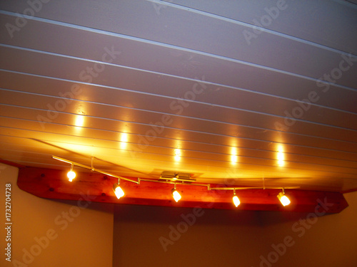 Modern ceiling chandelier with lights on in the living room