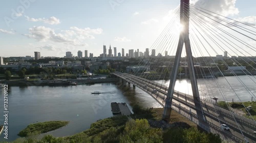 Aerial drone view of Świętokrzyski Bridge and Warsaw skyline at sunrise with sun rays, Poland