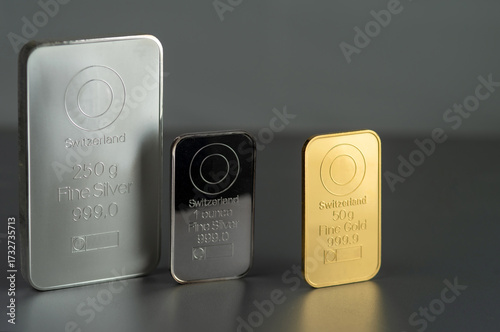 Gold and silver bars of various weights on a dark background.Selective focus.