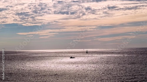 Amanecer en el mar Mediterráneo con velero y barco vistos desde dron en Barcelona