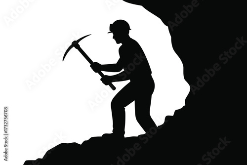 Silhouette of a miner working with a pickaxe in a dark cave entrance