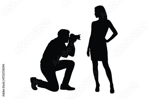 Photographer kneels to capture silhouette of fashion model posing