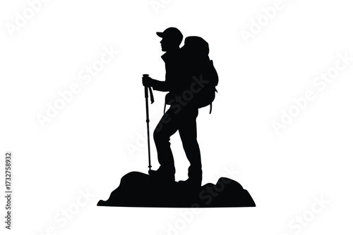 Silhouette of a hiker with backpack and trekking poles on rocky terrain