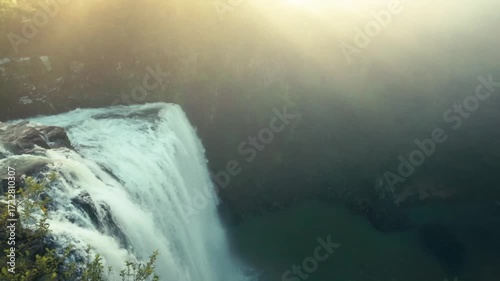 Looking over the edge of a waterfall at sunset.