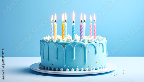 Blue frosted birthday cake with eight lit candles in pink and blue, topped with colorful flowers and berries, set on a white board against a light blue background.
