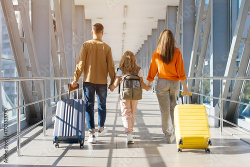 Caucasian family walking away at airport with luggage, holding hands and backpacks, symbolizing unity, bonding, lifestyle and joyful holiday travel departure together