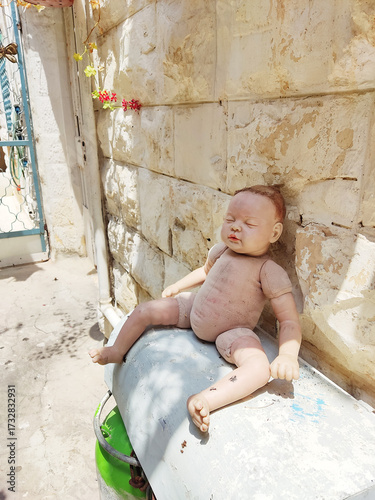 Eerie Doll Resting Against a Stone Wall