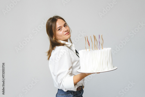 Elegant smiling woman holding cake, standing over white background. Space for text