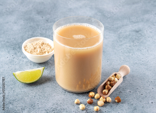 Sattu sharbat is an Indian drink made from roasted black chickpea flour, sugar and water on a blue background