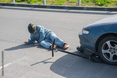 A Caucasian woman on a scooter after being hit by a car.