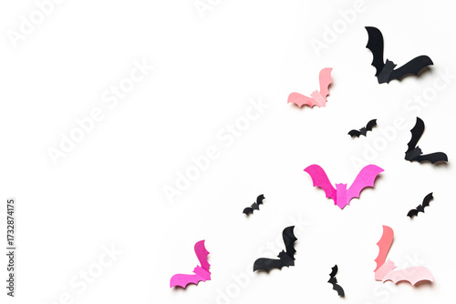 Pink and black paper bats on white background.